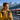 A traveler checks her smartphone and a SIM card on a sunny train platform with the Alps in the background